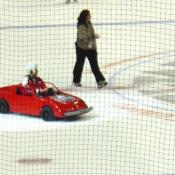 This youngster enjoys a quick trip around the ice in his sporty red convertible during intermission.