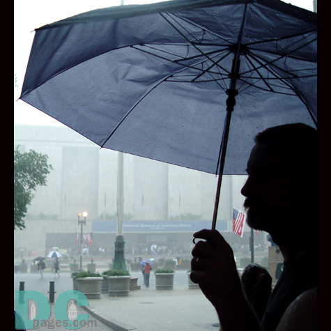 A man stands on the steps on the Mellon Auditorium, across from the Smithsonian Museum of American History.