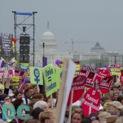 Planned Parenthood activists STAND UP FOR CHOICE! in front of the U.S. Capitol at the March for Women's Lives.  Other marchers hold signs that ask WHO DECIDES? and state CHOICE = FREEDOM.