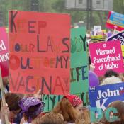 Two marchers carry handwritten placards that read KEEP YOUR LAWS OUT OF MY VAGINA! and MY BODY, MY LIFE, MY CHOICE.  On the right, supporters of reproductive rights from Planned Parenthood of Idaho.