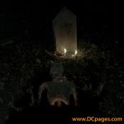 This skeleton hangs by its neck underneath its tombstone.