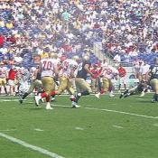 The players hussle to the ball after kick-off.