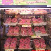 MMM... SPRINKLICIOUS - Racks of tasty doughnuts waiting to be eaten.