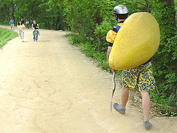 A lone kayaker walking along the canal path towards the drop-in point for the competition.