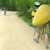 A lone kayaker walking along the canal path towards the drop-in point for the competition.