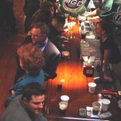 Patrons and bartenders converse along Fin Mac Cool's solid 43 foot long cherry wood bar.