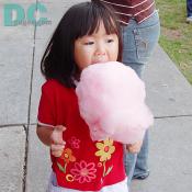 A pretty girl had a bite of her pink Wata-ame. 