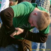 Wringing out beer spilled all over his shirt.