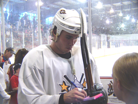 Sutherby signs autographs for fans.