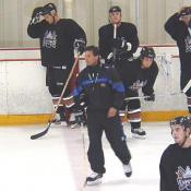 Coach Cassidy skates with his team during their practice.