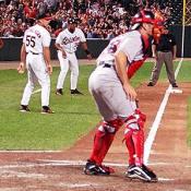 A Boston Red Sox catcher prepares himself to stop the O's from scoring.
