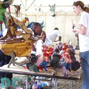 A woman is intrigued by the rooster.