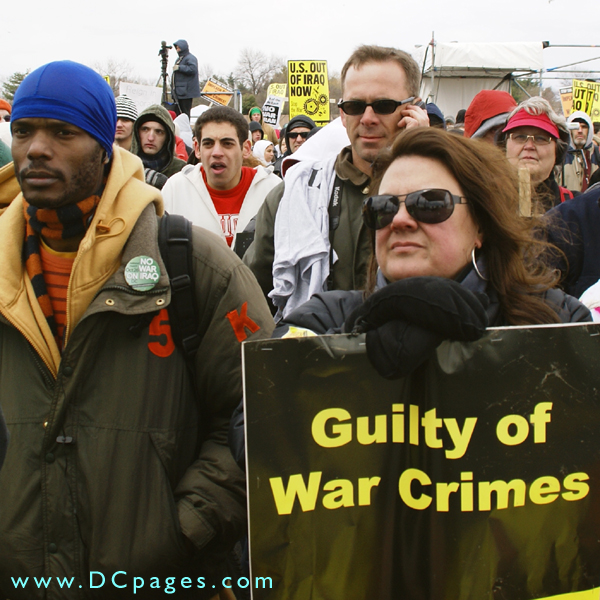 Woman hold up sign - Guilty of War Crimes.