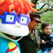 A United States Marine and her son stand for pictures with Chuckie, a character from the cartoon, "Rugrats."