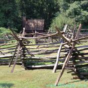 The cross pieces and the rider (top beam) keep the fence in place to keep deer and cattle out of the pioneer kitchen garden.