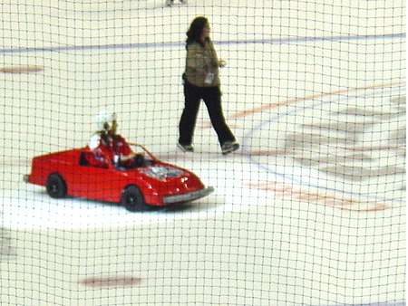 This youngster enjoys a quick trip around the ice in his sporty red convertible during intermission.