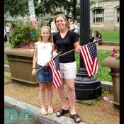 This mother and daughter show their patriotism with American flags.