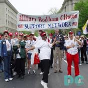 A group of marchers carry a banner: HILLARY RODHAM CLINTON SUPPORT NETWORK.