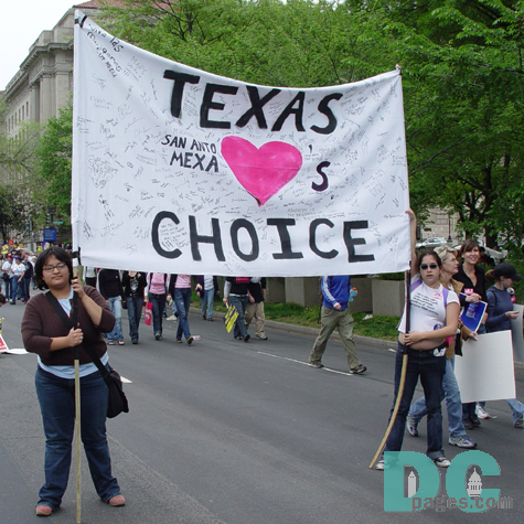 Two marchers from Texas carry a signed banner TEXAS LOVES CHOICE [shown with a drawing of a heart]