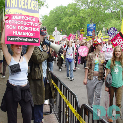 Pro-Life advocates used bullhorns to express their views to marchers.  On pro-choice marcher crossed the barracade holding her Planned Parenthood sign.