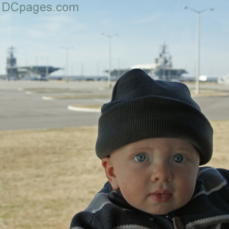 Luke Jr. in front of two Navy Aircraft Carriers