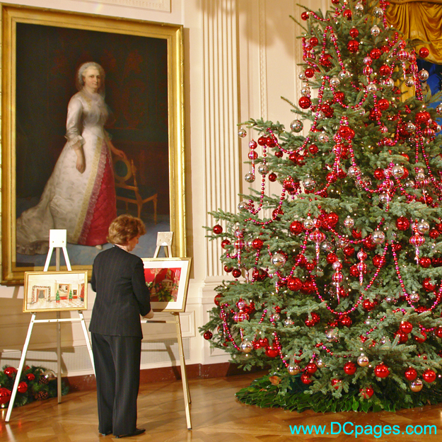 White House staff member adjusts paintings before the arrival of the First Lady. Painting of Martha Washington in the background.