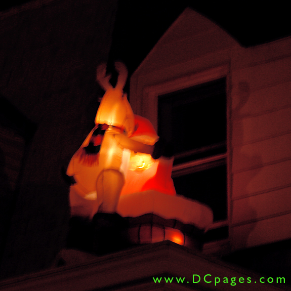 A closeup view of an inflatable reindeer helps Santa down the chimney.
