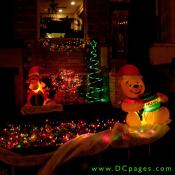 An inflatable Winnie the Pooh and Tigger are surrounded by a green spiral tree, and many multicolored lights.