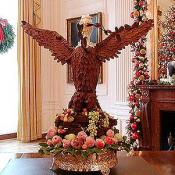 Located in the State Dining room, this eagle made of gold hydrangea leaves stands over a mahogany center table, along with candelabra and urns from the White House vermeil collection