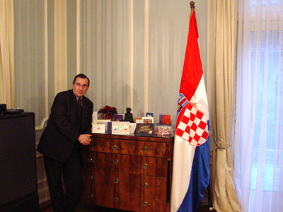 The Croatian Embassys' Aid standing next to a table convered with Christmas cards