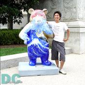 In front of National Archives at 9th and Constitution Ave., N.W., a Japanese boy is posing with "Zen Panda" by Suzanne Pender 