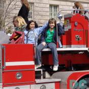 Two St Patricks Day girls have fun on a red Seagrave Fire Truck