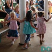 These little girls have fun twirling around a barn pole.