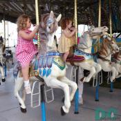 A carousel is a great amusement ride for young ones to have fun going around a on a painted wooden horse.