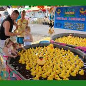 This father checks the bottom of the rubber duckies for a prize.