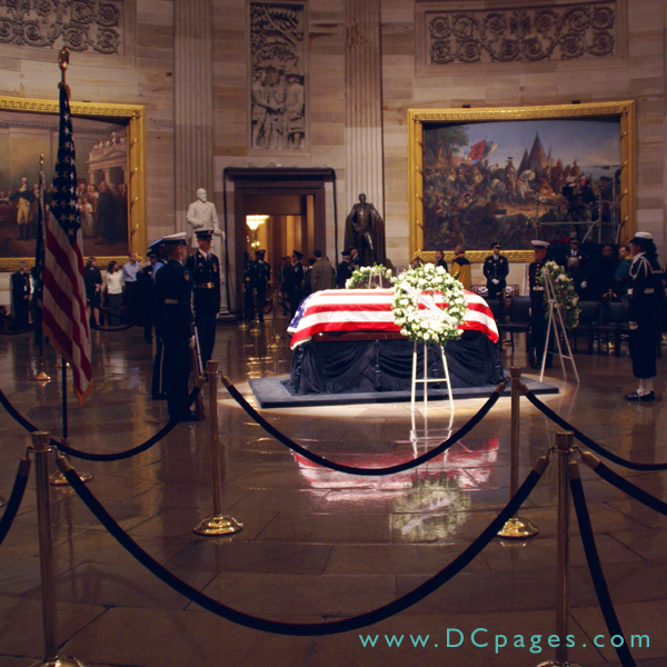 The Lying of State, President Gerald Ford, United States Capitol Rotunda. An American flag is draped over the casket. Two wreaths are displayed with the words 'House of Representatives' (shown) and 'United States Senate.'