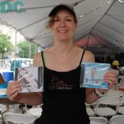 Blues volunteer holds up cds of Mary Ann Redmond and Robert Lighthouse.