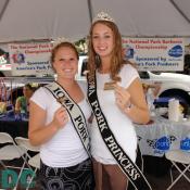 The Iowa Pork Queen and the Iowa Pork Princess pass out sausage patties for people to try.