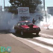 1983 Ford Mustang choking some spectators in the burn-out pit.