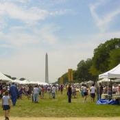 Visitors exploring the many tents filled with crafts, presentations, food, music, and the Washington Monument in the background