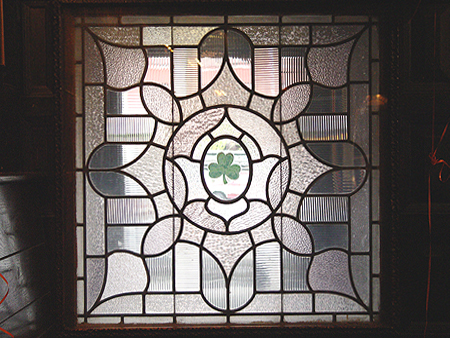 A Celtic stain glass window with a shamrock in the center.