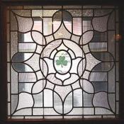A Celtic stain glass window with a shamrock in the center.