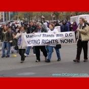 Marchers carry a large banner - Maryland Stands with D.C. - Voting Rights Now!