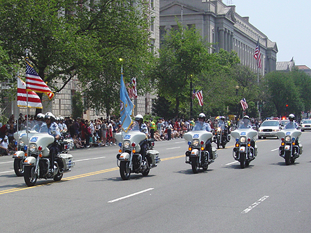 The motorcycle police ride by in a roaring armada.  