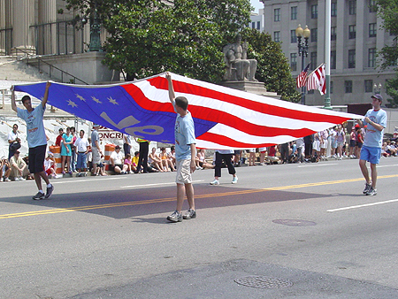4 men holding the US. flag held high