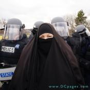 An Islamic woman stands in front of Virginia State Police.