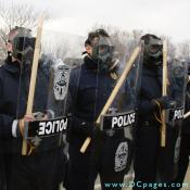 Virginia State Police wearing gas masks and wielding batons.