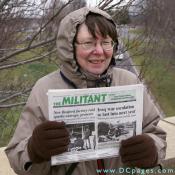 This woman holds up a copy of 'The Militant' newspaper.