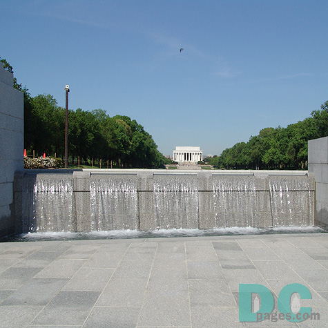 West to East View of the World War II Memorial. A bird flies over the Lincoln Memorial in the background. Water fall in the foreground.
