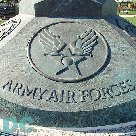 A bronze flag base adorned with the military service seals of the Army, Navy, Marine Corps, Army Air Forces, Coast Guard and Merchant Marine. 